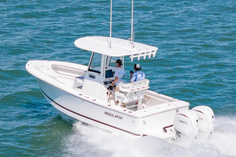 Slide: The Image of 2026 Regulator 23 boat cruising on open water with twin Yamaha engines. - 4