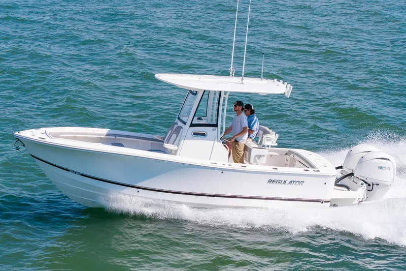 The Image of 2026 Regulator 23 boat cruising on open water with two passengers. - 2
