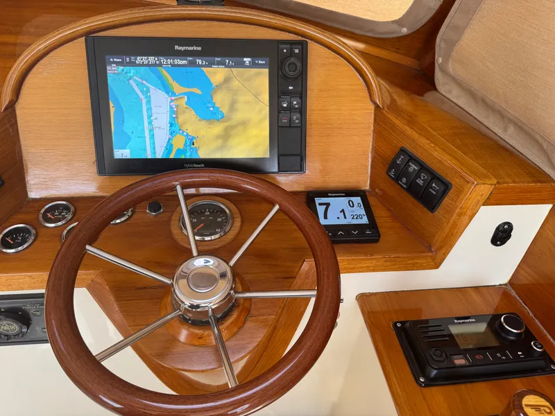 Slide: The Image of 1999 Hinckley Picnic boat helm with Raymarine navigation system and wooden steering wheel. - 12
