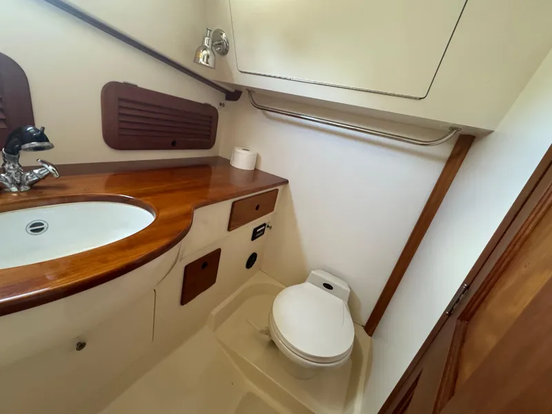 Slide: The Image of 1999 Hinckley Picnic boat bathroom with wooden countertop and compact toilet. - 15