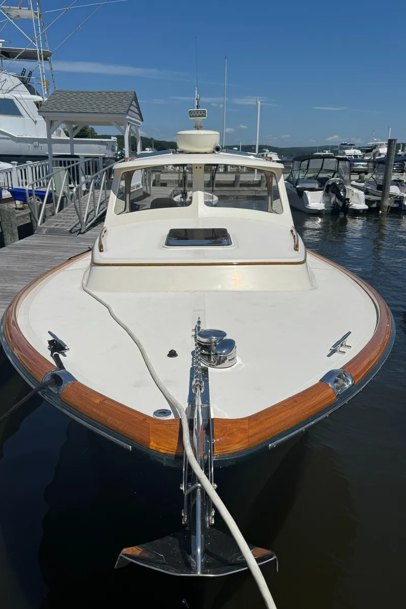 Slide: The Image of 1999 Hinckley Picnic boat docked at a marina, showcasing elegant design and craftsmanship. - 26