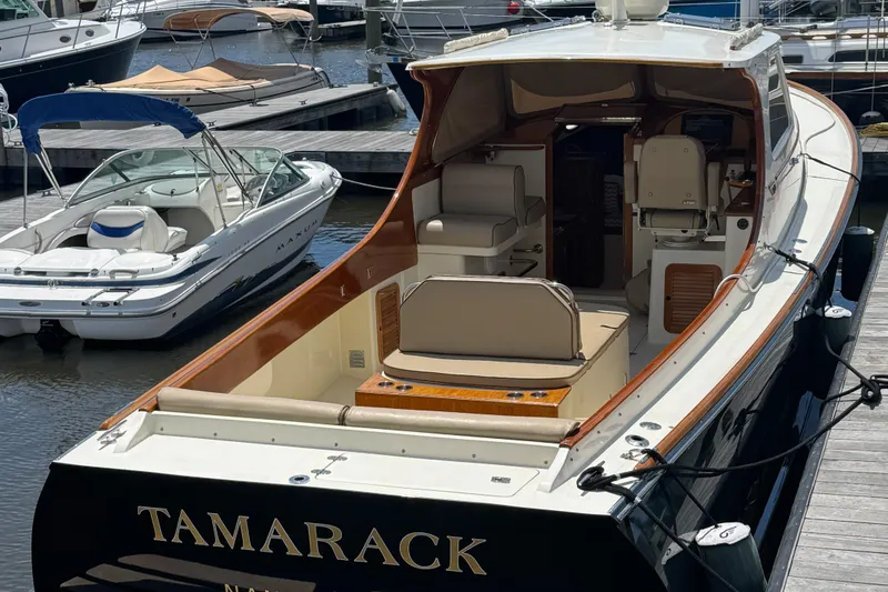 Slide: The Image of 1999 Hinckley Picnic boat docked, featuring elegant seating and classic design. - 8