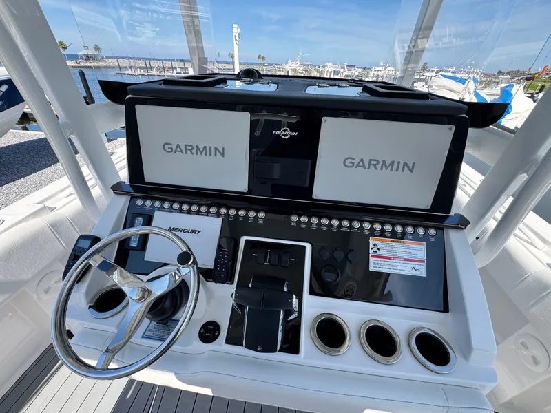 Slide: The Image of Control panel of 2025 Fountain 34 TE boat with Garmin displays and Mercury steering wheel. - 14