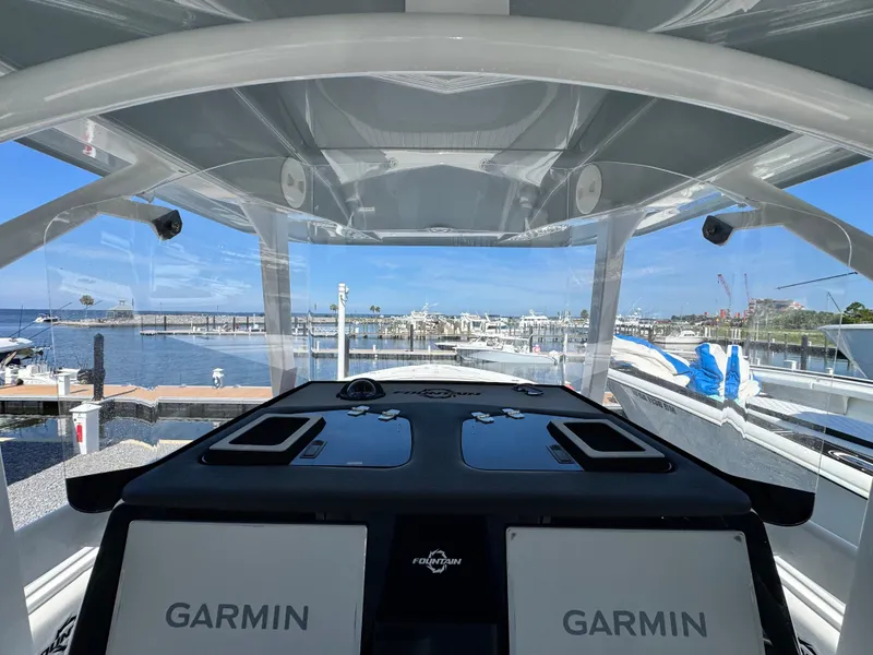 Slide: The Image of 2025 Fountain 34 TE boat dashboard with Garmin displays, overlooking marina and waterfront. - 15
