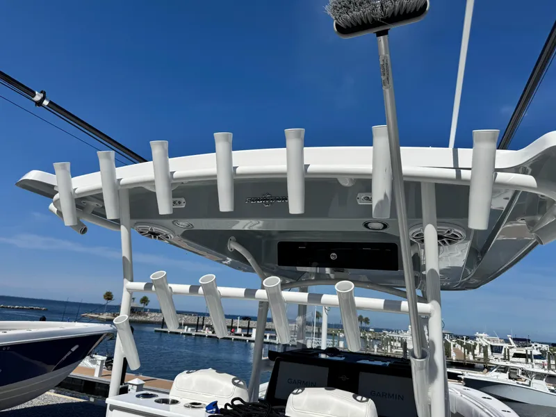 Slide: The Image of 2025 Fountain 34 TE boat with rod holders, docked at marina under clear blue sky. - 23