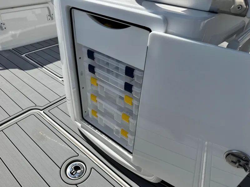 Slide: The Image of Storage compartment with tackle boxes on a 2025 Fountain 34 TE boat deck. - 24