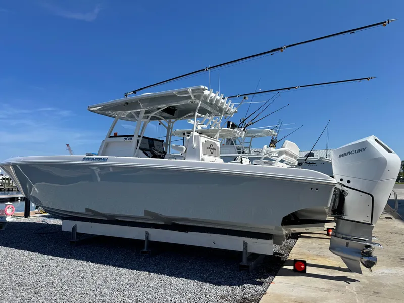 Slide: The Image of 2025 Fountain 34 TE boat with Mercury engines on a trailer, under clear blue sky. - 3