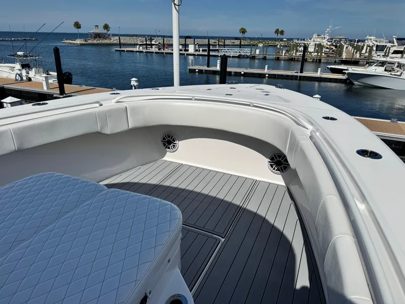 Slide: The Image of 2025 Fountain 34 TE boat interior with cushioned seating, docked at a marina. - 8