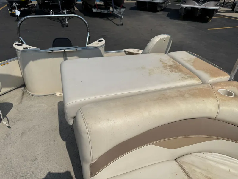 Slide: The Image of 2006 Sweetwater 23860DF boat interior with worn beige seating and cup holder. - 12