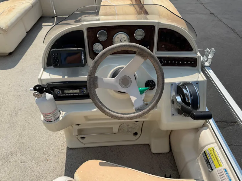 Slide: The Image of Steering console of a 2006 Sweetwater 23860DF boat with gauges and controls. - 16