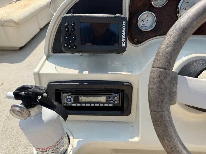 Slide: The Image of Console of a 2006 Sweetwater 23860DF boat with Lowrance device and fire extinguisher. - 18