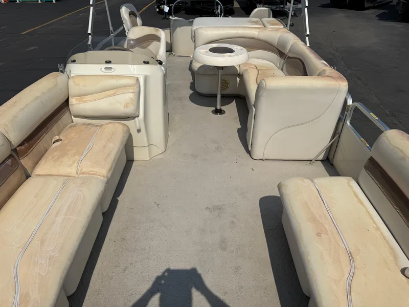 Slide: The Image of 2006 Sweetwater 23860DF pontoon boat interior with beige seating and central table. - 7
