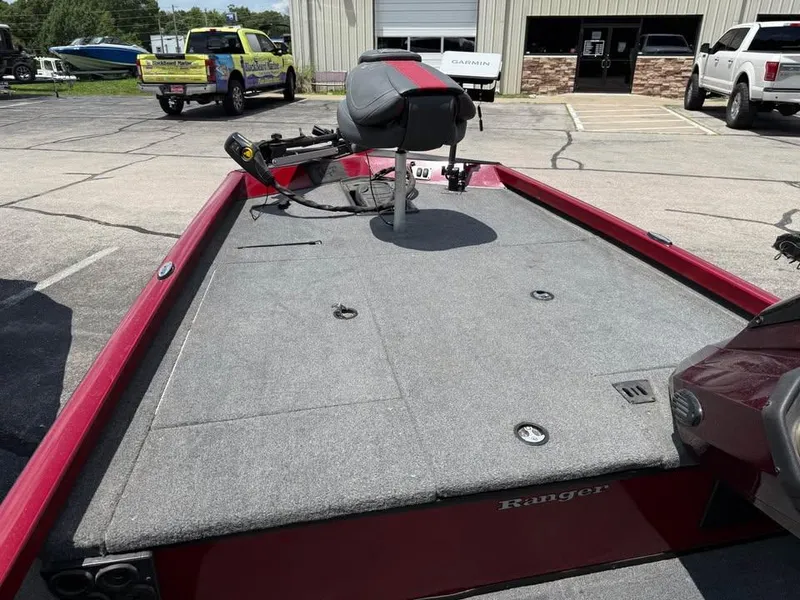 Slide: The Image of 2023 Ranger RT 188 boat with red trim and fishing seat, parked outdoors. - 13