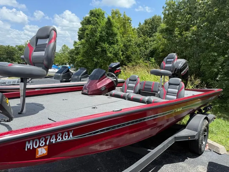 Slide: The Image of 2023 Ranger RT 188 boat with red and gray seating, parked on a trailer. - 3