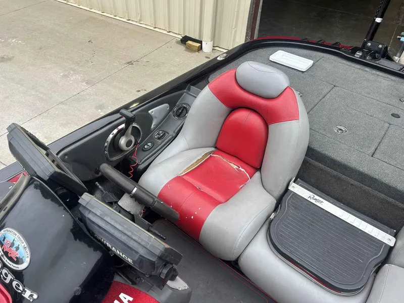 Slide: The Image of 2009 Ranger Z520 boat interior with red and gray seating, steering wheel, and control panel. - 7