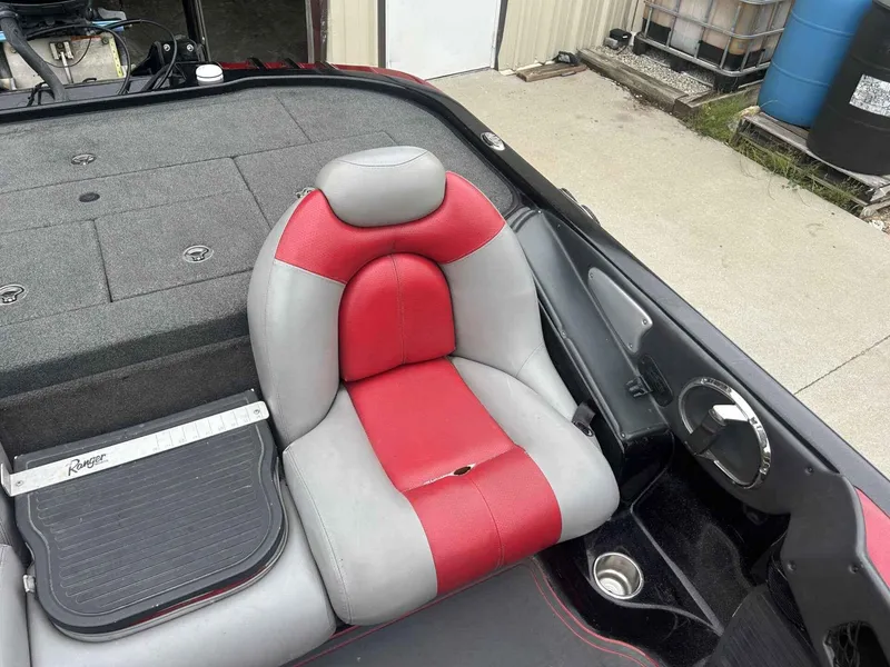 Slide: The Image of Red and gray seat in a 2009 Ranger Z520 boat, with storage compartments and a measuring board. - 8