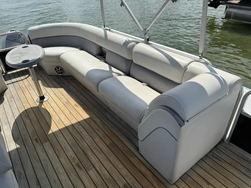 Slide: The Image of Sanpan 25 pontoon boat interior with gray seating and wooden deck, 2000 model. - 13