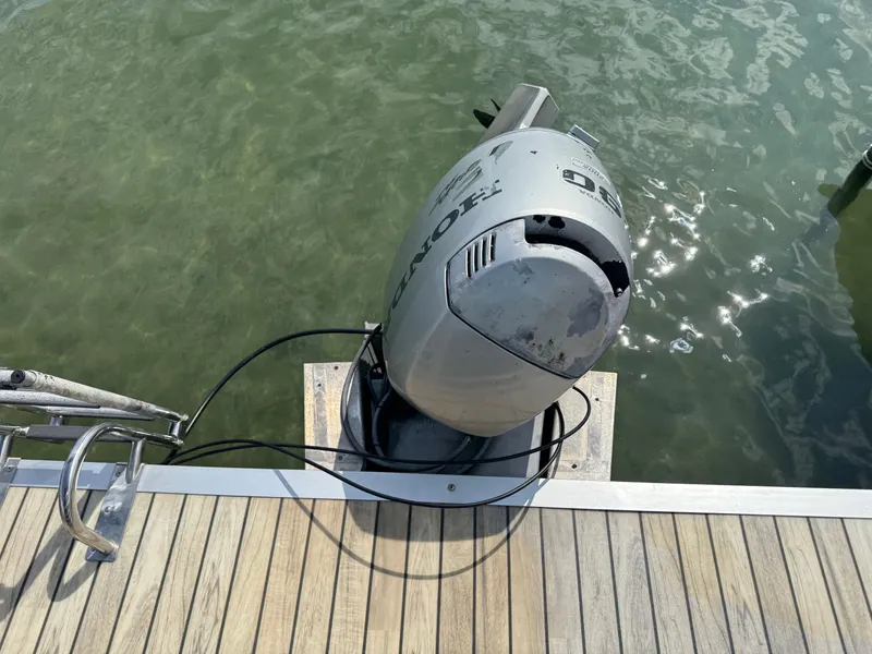 Slide: The Image of Outboard motor on a docked Sanpan 25 boat, 2000 model, near clear water. - 16
