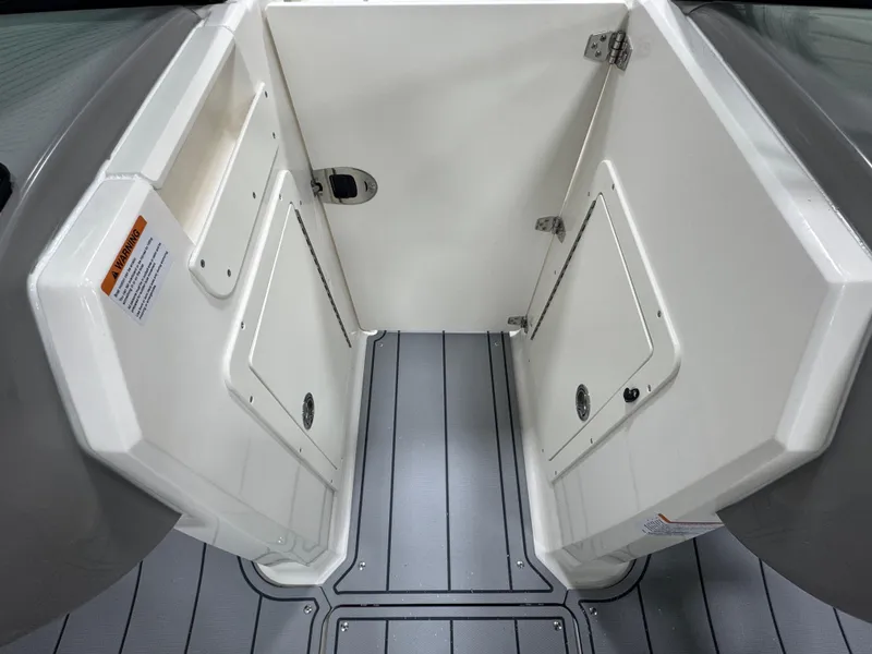 Slide: The Image of 2025 Chaparral 21 SSi boat interior with storage compartments and gray flooring. - 11