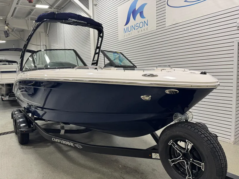 Slide: The Image of 2025 Chaparral 21 SSi boat on trailer in showroom, Munson Surf & Wake signage. - 15