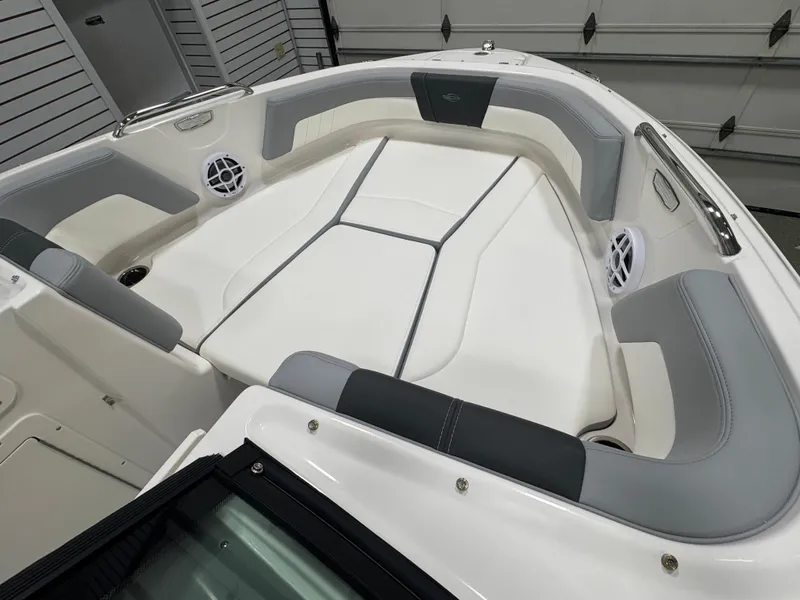 Slide: The Image of 2025 Chaparral 21 SSi boat interior with white and gray seating, cup holders, and speakers. - 9