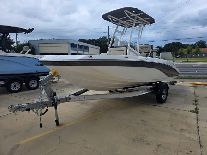 The Image of 2025 Yamaha Boats 195 FSH Sport on trailer, parked outdoors, overcast sky. - 1