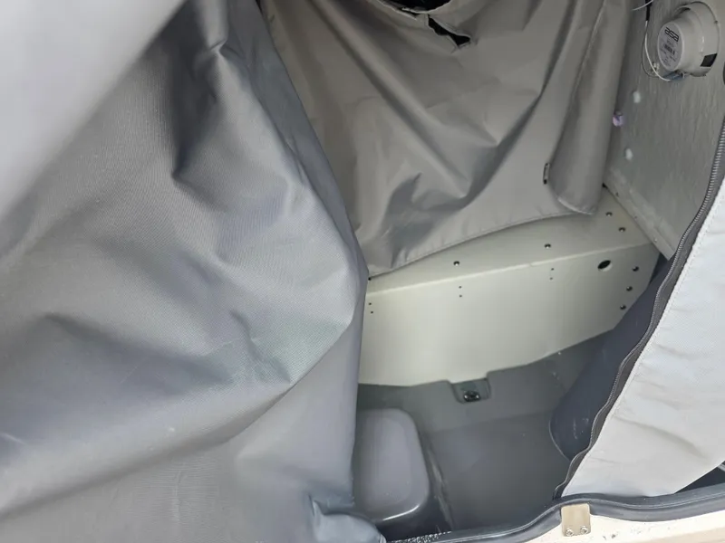 Slide: The Image of Interior view of 2025 Yamaha Boats 195 FSH Sport, featuring storage compartment with gray fabric lining. - 12