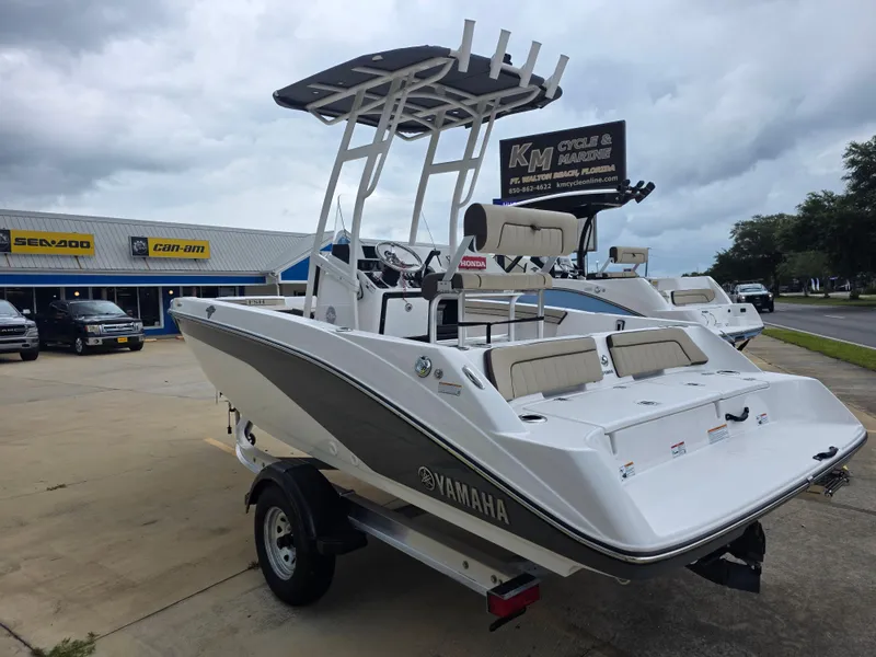 Slide: The Image of 2025 Yamaha Boats 195 FSH Sport displayed at a marine dealership under cloudy skies. - 4