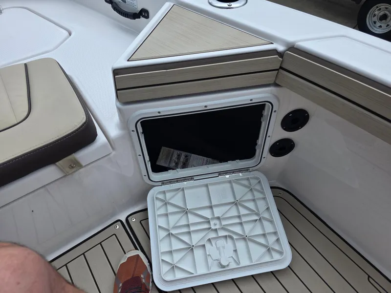Slide: The Image of 2025 Yamaha Boats 195 FSH Sport storage compartment with open hatch, showcasing interior details. - 5