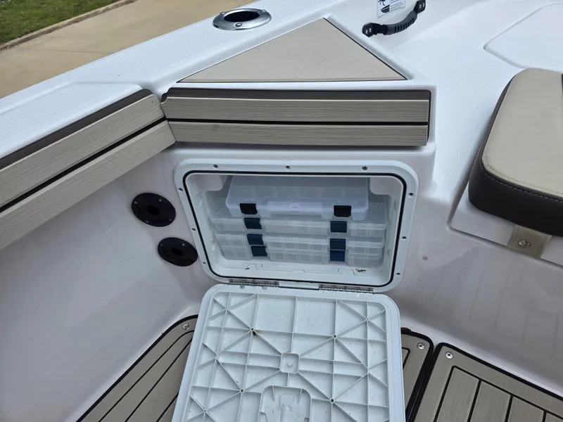Slide: The Image of 2025 Yamaha Boats 195 FSH Sport storage compartment with open lid and organized containers. - 6