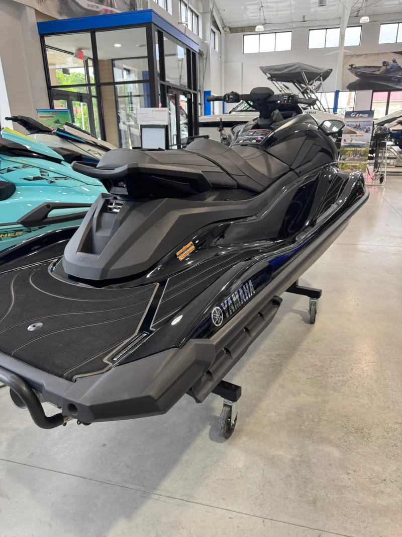 Slide: The Image of 2024 Yamaha WaveRunner GP1800R SVHO in showroom, sleek black design, side view. - 2