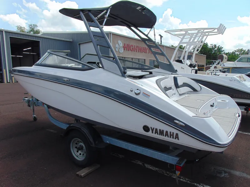 Slide: The Image of 2020 Yamaha Boats 195S on trailer, parked outdoors near a building. - 4