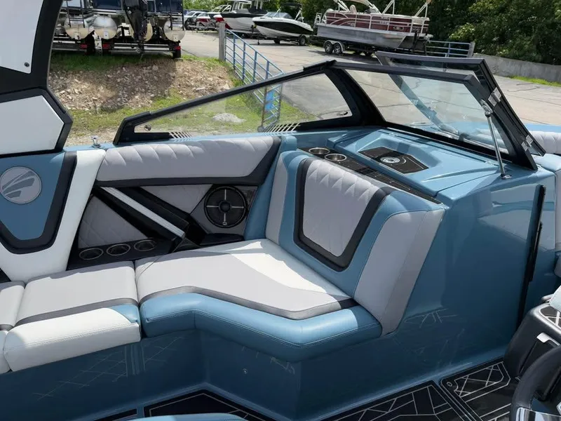 Slide: The Image of 2022 Tigé 21ZX boat interior with blue and gray seating, cup holders, and speaker. - 12