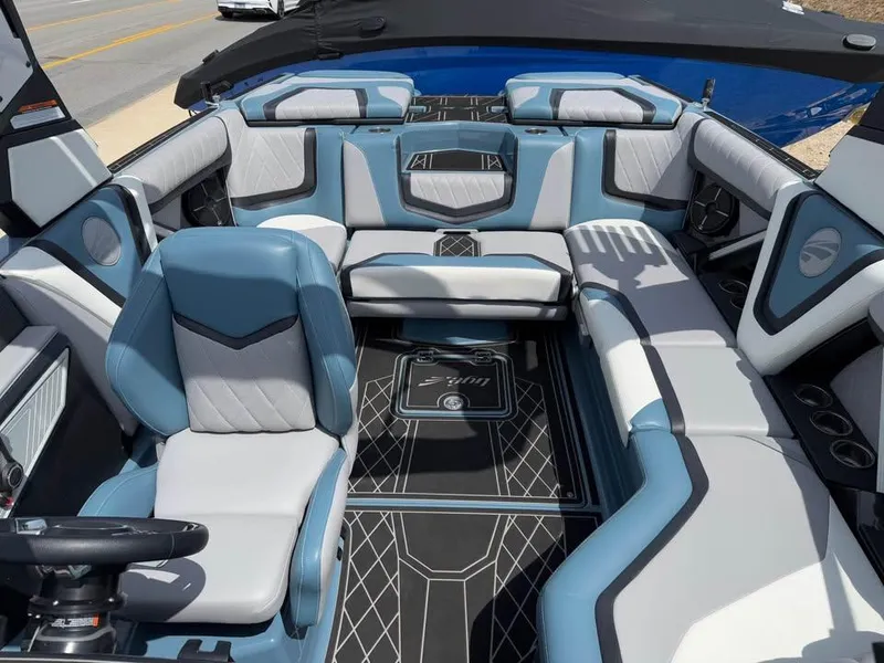 Slide: The Image of 2022 Tigé 21ZX boat interior with blue and gray seating, modern design, and spacious layout. - 14