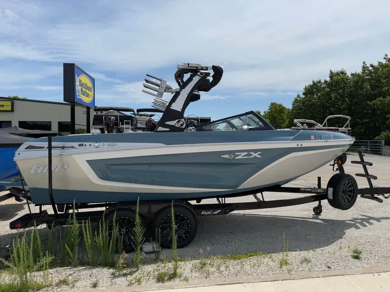 Slide: The Image of 2022 Tigé 21ZX boat on trailer, parked outdoors near dealership. - 4