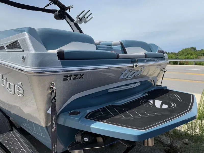 Slide: The Image of 2022 Tigé 21ZX boat rear view with sleek design and blue accents. - 6