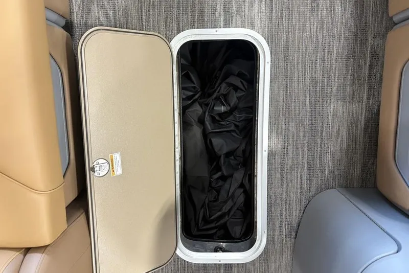 Slide: The Image of Storage compartment on 2025 Godfrey Sweetwater 2286 SB pontoon boat, open with black cover inside. - 11