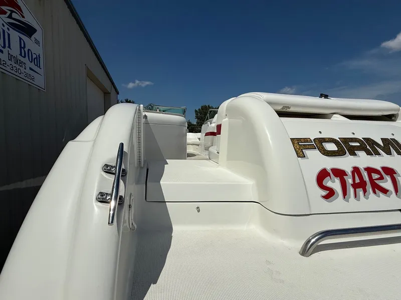 Slide: The Image of 2001 Formula F-260 boat exterior with white deck and branding, docked near a building. - 10