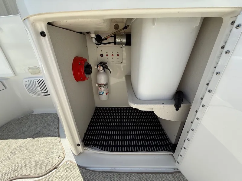 Slide: The Image of Storage compartment in a 2001 Formula F-260 boat, featuring safety equipment and controls. - 24