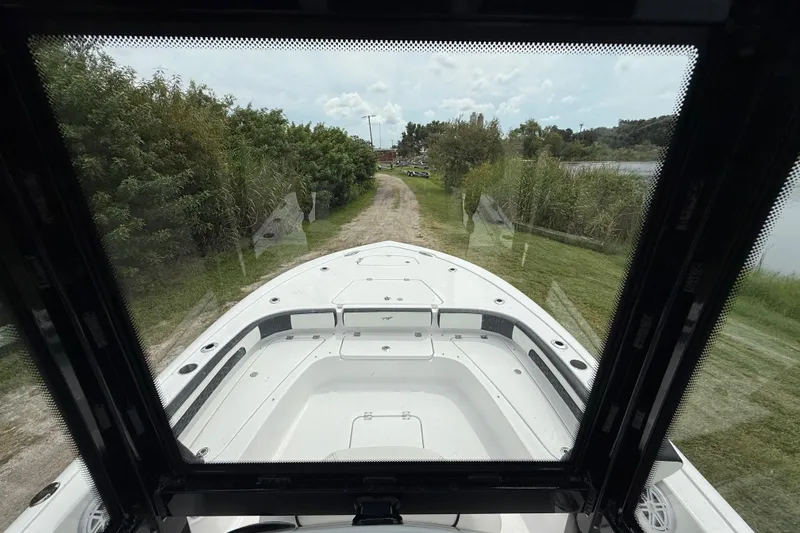Slide: The Image of 2026 Tidewater 2300 Carolina Bay boat on a grassy path near a lake. - 15