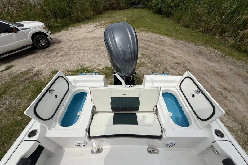 Slide: The Image of 2026 Tidewater 2300 Carolina Bay boat with open storage compartments and outboard motor. - 24
