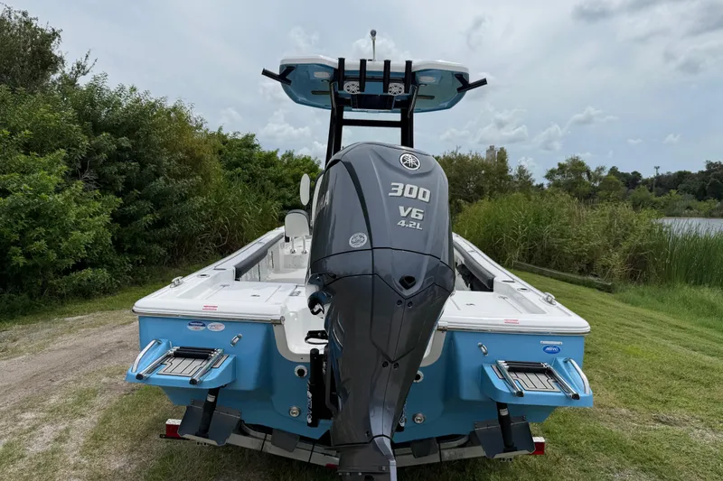 Slide: The Image of 2026 Tidewater 2300 Carolina Bay boat with Yamaha 300 V6 engine, parked near lush greenery. - 3