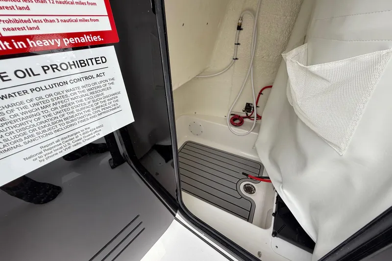 Slide: The Image of Interior of 2026 Tidewater 2300 Carolina Bay boat with storage and warning label. - 31