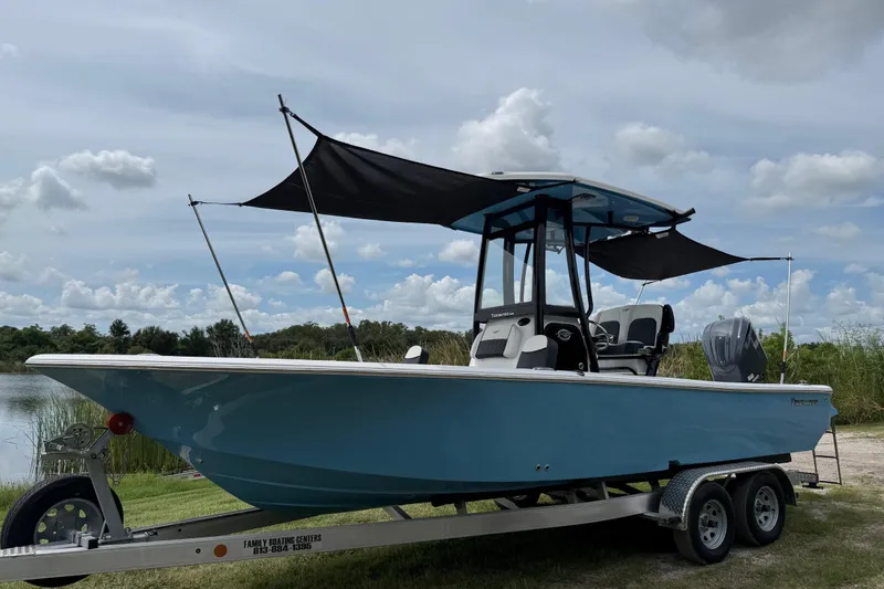 Slide: The Image of 2026 Tidewater 2300 Carolina Bay boat on trailer, featuring blue hull and black canopy. - 40