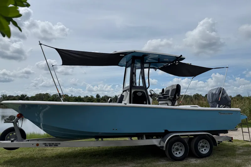 Slide: The Image of 2026 Tidewater 2300 Carolina Bay boat on trailer, parked near a lake under cloudy sky. - 41
