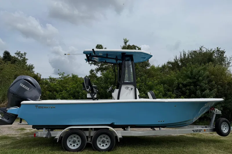 Slide: The Image of 2026 Tidewater 2300 Carolina Bay boat on trailer, blue hull, Yamaha engine, outdoor setting. - 8