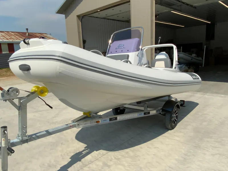 Slide: The Image of 2026 Gala V420 boat on trailer outside a garage. - 7