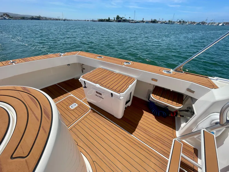 Slide: The Image of 1998 Viking 50 Convertible yacht deck with teak flooring, ocean view, and storage compartments. - 20