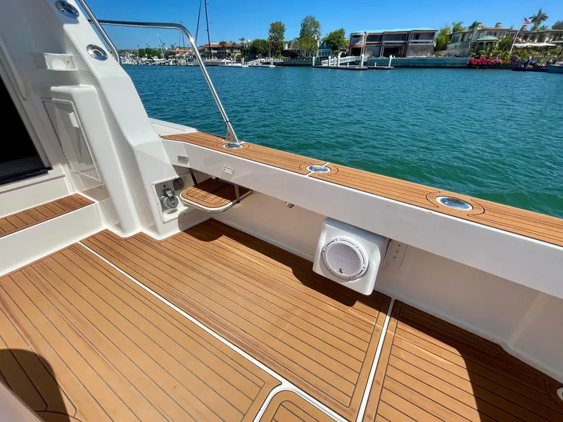 Slide: The Image of 1998 Viking 50 Convertible yacht deck with teak flooring, overlooking serene marina waters. - 22