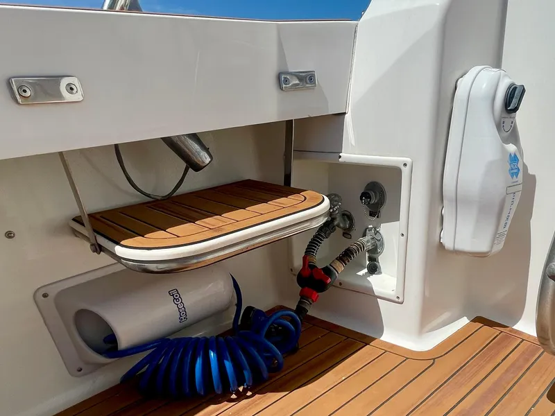 Slide: The Image of 1998 Viking 50 Convertible yacht deck with teak flooring and hose storage. - 24